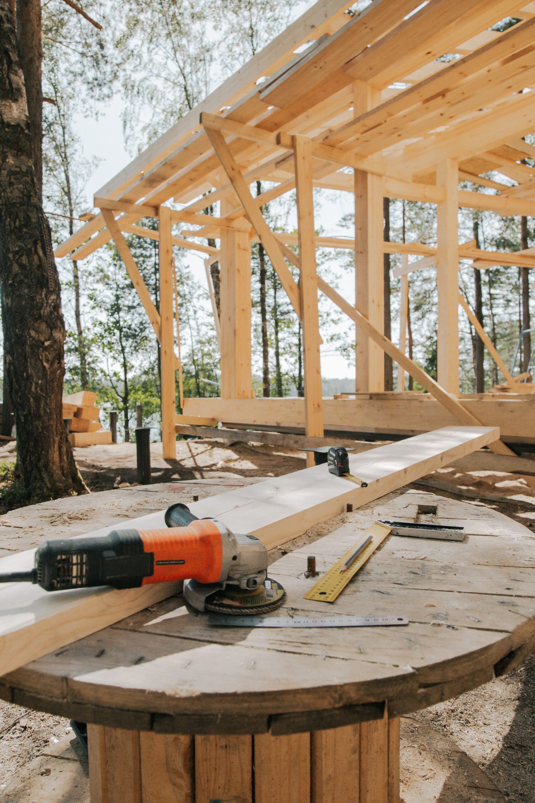 A scenic view of woodworking tools and wooden frame at a forest construction site.